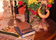 Books on table with flowers, wine bottle and glass